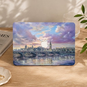 May include: A laptop skin featuring an oil painting of the London skyline at sunset. The scene depicts the River Thames, Westminster Bridge, and the Elizabeth Tower under a vibrant sky filled with purple, pink, and blue clouds, with an Apple logo cutout.