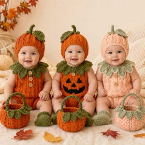 Peut inclure: Trois nourrissons portant des tenues en crochet sur le thème de la citrouille, incluant des bonnets avec des feuilles vertes et des barboteuses avec des cols verts et des boutons en bois. Le bébé central porte un motif de citrouille d'Halloween.