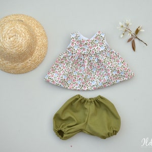 May include: A doll outfit set with a floral print dress, green bloomers, and a straw hat.