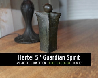 May include: A bronze-coloured sculpture, labelled "Hertel 5" Guardian Spirit," stands on a wooden surface. The sculpture is approximately 13 cm tall and has a stylized human form. The base is rectangular, and the top has a rounded head. The words "Wonderful Condition" are also visible.
