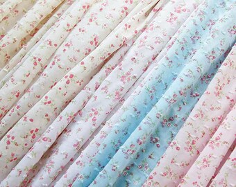 以下が含まれることがあります： 小さなピンクと赤の花柄が施された、軽量で半透明の生地のストリップのコレクション。素材には繊細な隆起したドットのテクスチャがあり、白、青、ピンクの斜めのひだに配置されています。