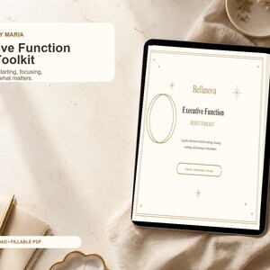 May include: A digital tablet displaying the Executive Function Reset Toolkit by Bellanova by Maria. The screen shows a beige document with gold line art, including a crescent moon, stars, and circles, with the text Executive Function Reset Toolkit.
