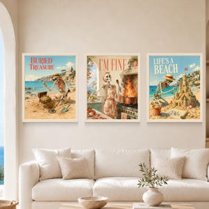May include: Three framed wall art prints featuring skeleton illustrations. The left print shows a skeleton with a metal detector and the text BURIED TREASURE. The center print shows a skeleton cooking with fire and the text I'M FINE. The right print shows a skeleton building a sandcastle and the text LIFE'S A BEACH.