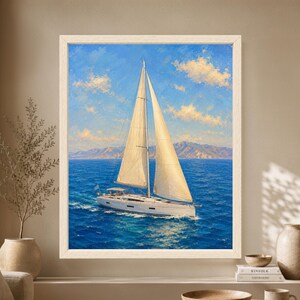 Framed sailboat wall art showing a white sailing yacht with tall cream sails crossing a vivid blue ocean beneath a bright sky and distant mountain coastline.