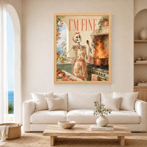 May include: A framed wall art print featuring a skeleton wearing a floral apron and matching headscarf, standing in a kitchen. The skeleton holds a wooden spoon near a pot with large flames on a stove. The text I'M FINE is printed at the top.