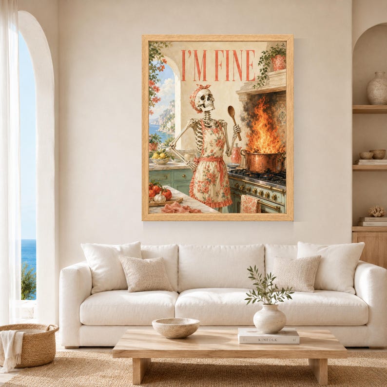 May include: A framed wall art print featuring a skeleton wearing a floral apron and matching headscarf, standing in a kitchen. The skeleton holds a wooden spoon near a pot with large flames on a stove. The text I'M FINE is printed at the top.