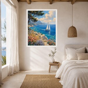 May include: A framed wall art print featuring a coastal landscape painting with a white sailboat on deep blue water, rocky cliffs, and colorful wildflowers in the foreground under a bright sky with fluffy white clouds in a white frame.