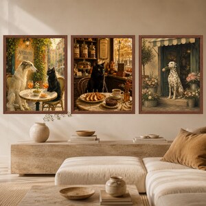 May include: A set of three framed wall art prints. The left print shows a Borzoi dog and a black cat at an outdoor cafe. The centre print features a black cat in a bakery. The right print depicts a Dalmatian dog holding a flower in a shop doorway.
