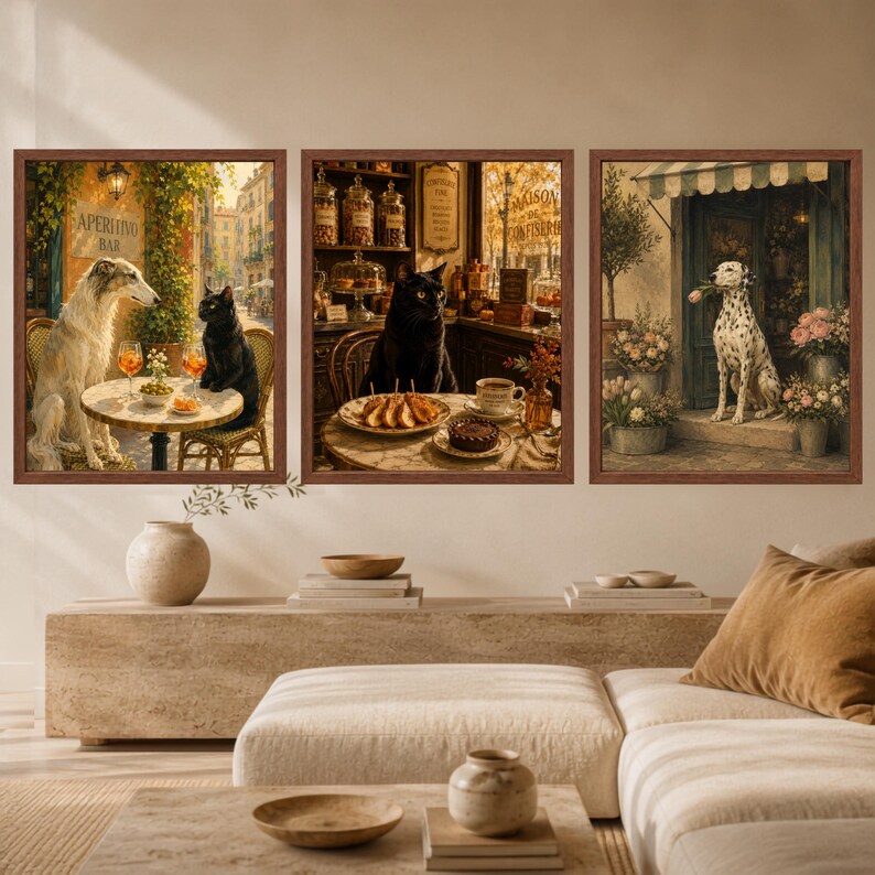 May include: A set of three framed wall art prints. The left print shows a Borzoi dog and a black cat at an outdoor cafe. The centre print features a black cat in a bakery. The right print depicts a Dalmatian dog holding a flower in a shop doorway.