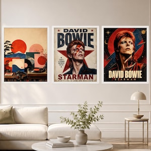 May include: Three framed wall art prints featuring David Bowie. The left print shows a Japanese-inspired landscape with a red sun and vinyl records. The center print displays a portrait of Bowie with the text DAVID BOWIE STARMAN. The right print features a portrait of Bowie with a lightning bolt and the text DAVID BOWIE STARMAN.