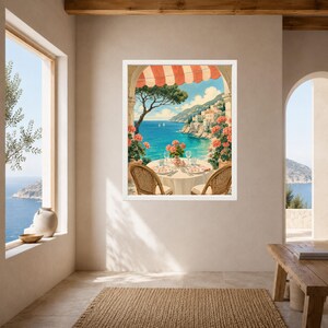 May include: A framed wall art print depicting a coastal Mediterranean scene under a red and white striped awning. The image shows a round table set for two with pink flowers, overlooking a blue sea, distant cliffs, and white hillside buildings.