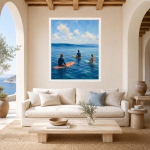 May include: A framed wall art print depicting three individuals sitting on surfboards in the middle of a deep blue ocean. The scene features a calm sea, a clear sky with scattered white clouds, and a distant horizon line under bright daylight.