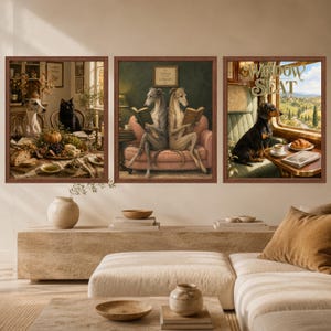 May include: A set of three framed wall art prints featuring anthropomorphic dogs. The left print shows a greyhound and black cat at a table, the center print shows two greyhounds reading on a sofa, and the right print shows a dachshund by a train window.