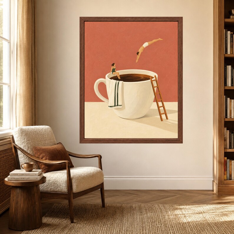May include: A framed wall art print featuring a large white coffee cup on a beige surface against a terracotta background. A person in a green swimsuit sits on the rim with a towel, while another person in white shorts dives into the dark liquid.