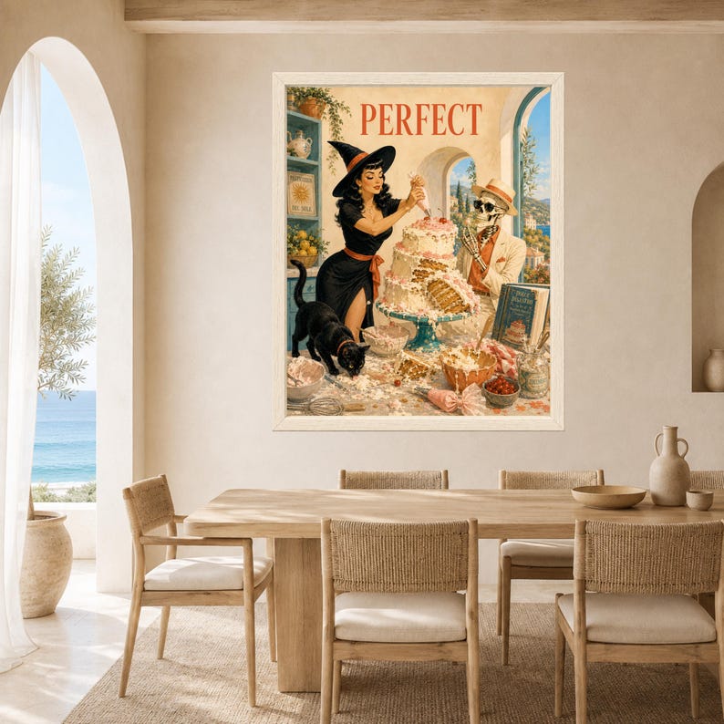 May include: A framed wall art print featuring a vintage-style illustration of a witch in a black dress and a skeleton in a suit decorating a multi-tiered cake. The word PERFECT is printed at the top. A black cat stands on the table nearby.