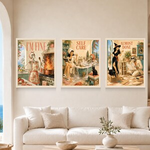 May include: Three framed wall art prints featuring retro-style illustrations. The left print shows a skeleton in an apron with the text I'M FINE. The center print depicts a person and a skeleton in a bathroom with the text SELF CARE. The right print shows a witch and a skeleton with the text ALMOST DONE.