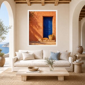 Pu&ograve; includere: Una stampa d'arte da parete incorniciata che raffigura una parete in stucco arancione vibrante con una porta in legno blu intenso. Un gatto arancione riposa sul gradino in pietra accanto a un cesto di vimini pieno di limoni gialli.