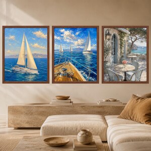 May include: A set of three framed wall art prints featuring nautical scenes. The first shows a sailboat on blue water, the second depicts a boat deck looking toward sailboats on the sea, and the third displays a patio with tables overlooking the ocean.