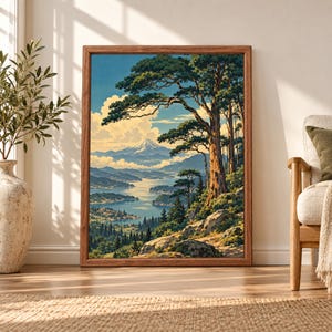 Framed Japanese landscape wall art showing a snow-capped mountain beyond a blue lake, layered forest hills and tall pine trees in a vintage woodblock-inspired style.