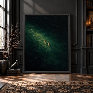 Framed dark emerald ocean wall art showing two small swimmers from above in deep green water with a narrow pool of reflected light and textured painterly surface.
