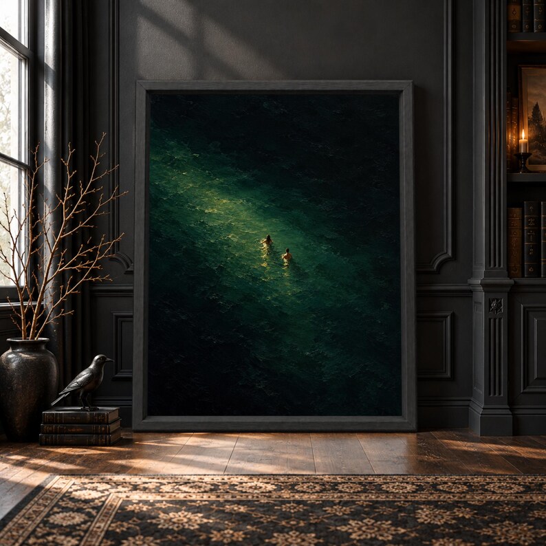 Framed dark emerald ocean wall art showing two small swimmers from above in deep green water with a narrow pool of reflected light and textured painterly surface.