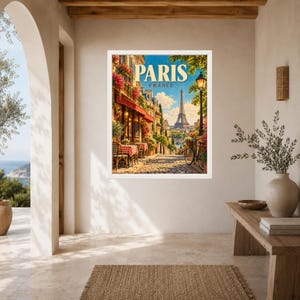 May include: A framed wall art print featuring a vibrant street scene in Paris, France. The image displays a sidewalk cafe with red and white checkered tablecloths, a bicycle, blooming flowers, and the Eiffel Tower in the distance under a blue sky.