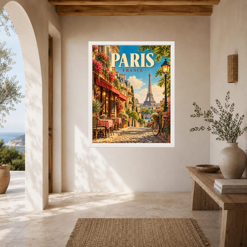 May include: A framed wall art print featuring a vibrant street scene in Paris, France. The image displays a sidewalk cafe with red and white checkered tablecloths, a bicycle, blooming flowers, and the Eiffel Tower in the distance under a blue sky.