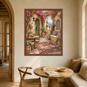 May include: A framed wall art print depicting a Mediterranean patio scene with a stone table, chairs, and a built-in bench. The scene features vibrant pink bougainvillea flowers, terracotta pots, a patterned rug, and an arched doorway leading to stairs.