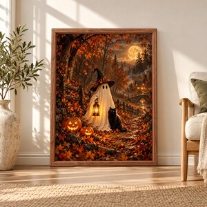 Framed Halloween ghost wall art showing a sheet ghost in a witch hat carrying a lantern beside a black cat and glowing jack-o-lanterns on a moonlit autumn forest path.