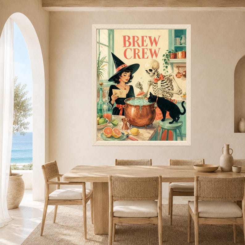 May include: A framed wall art print titled BREW CREW featuring a witch in a black hat, a skeleton, and a black cat gathered around a copper cauldron. The scene includes citrus fruits, bottles, and kitchen shelves in a warm, illustrated style.
