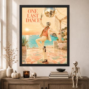 May include: A framed wall art print titled ONE LAST DANCE featuring a skeleton wearing a cream suit and orange shirt, dancing on a terrace overlooking a blue sea at sunset with a disco ball hanging above. The scene includes sailboats and a table.