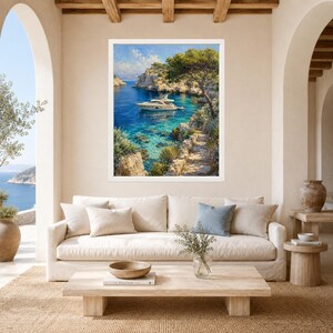 May include: A framed landscape painting depicting a white yacht floating on clear blue water in a rocky cove. The scene includes a stone path leading along the cliffside, lush green trees, and a bright sky with soft clouds above the coastal inlet.