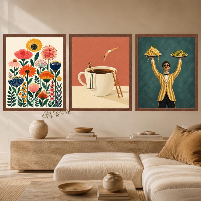 May include: Three framed wall art prints. The left print features colorful stylized flowers. The center print shows a person diving into a large coffee cup with another person sitting on the rim. The right print depicts a person holding two plates of pasta.