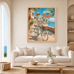 Peut inclure: Une impression d'art encadr&eacute;e repr&eacute;sentant un squelette portant un chapeau de paille et des lunettes de soleil, &agrave; v&eacute;lo bleu clair sur un chemin c&ocirc;tier. Le squelette a un panier avec un sac ray&eacute;. Le texte BONE TO ROAM est &eacute;crit en orange et bleu.