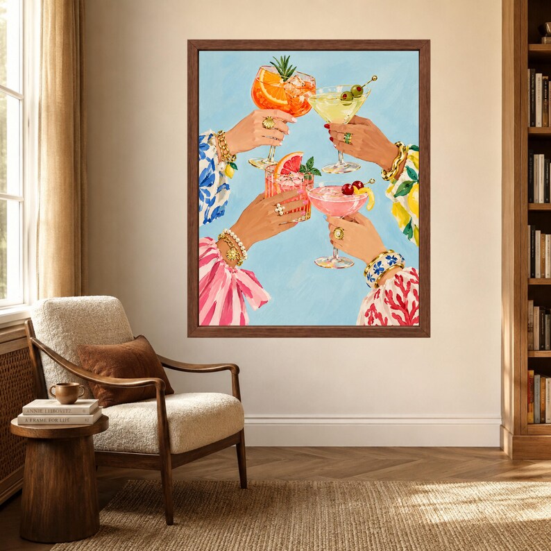 May include: A framed wall art print depicting four hands raised in a toast, each holding a different cocktail glass. The drinks are garnished with orange slices, olives, grapefruit, and cherries. The hands wear gold bracelets and rings.
