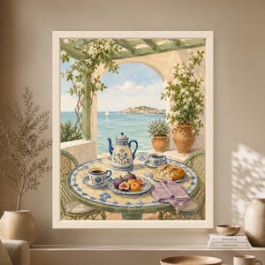 Framed Mediterranean breakfast wall art showing a blue and white mosaic terrace table with coffee, bread and figs beneath flowering vines, overlooking turquoise sea, a small island and a distant sailboat.