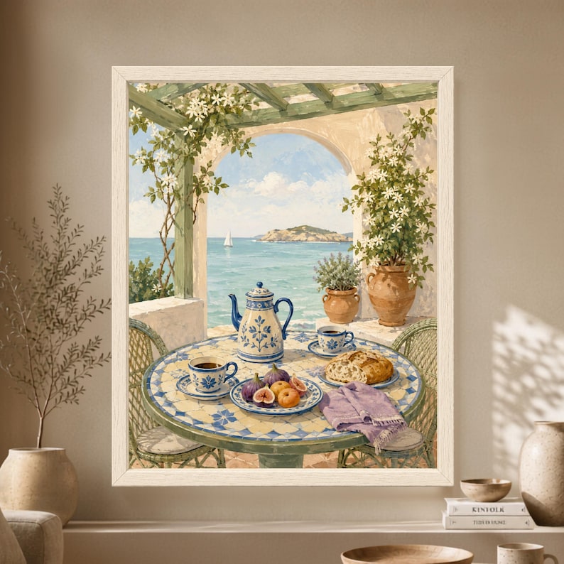 Framed Mediterranean breakfast wall art showing a blue and white mosaic terrace table with coffee, bread and figs beneath flowering vines, overlooking turquoise sea, a small island and a distant sailboat.