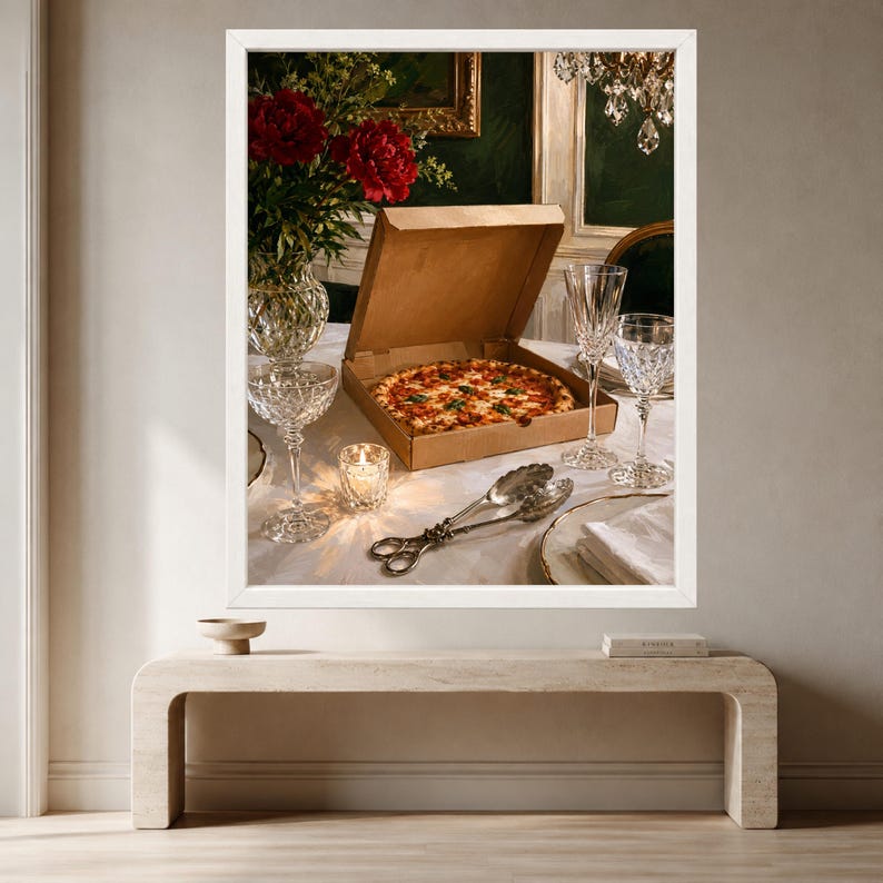 May include: A cardboard pizza box containing a round pizza with red sauce and toppings sits on a white tablecloth. Nearby are two crystal glasses, a small lit candle in a glass holder, silver serving tongs, and a vase of red flowers.