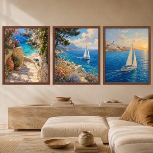 May include: A set of three framed wall art prints featuring coastal Mediterranean scenes. The left print shows a stone staircase leading to a turquoise cove, the center depicts a sailboat near a rocky cliff, and the right shows a sailboat at sunset.