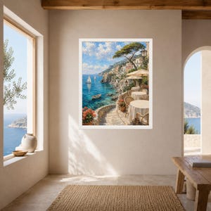 Pu&ograve; includere: Una stampa d'arte da parete incorniciata che raffigura una scena costiera mediterranea con una terrazza in pietra, tavoli rotondi coperti da tovaglie bianche e sedie che si affacciano su un mare blu con barche a vela, scogliere rocciose.
