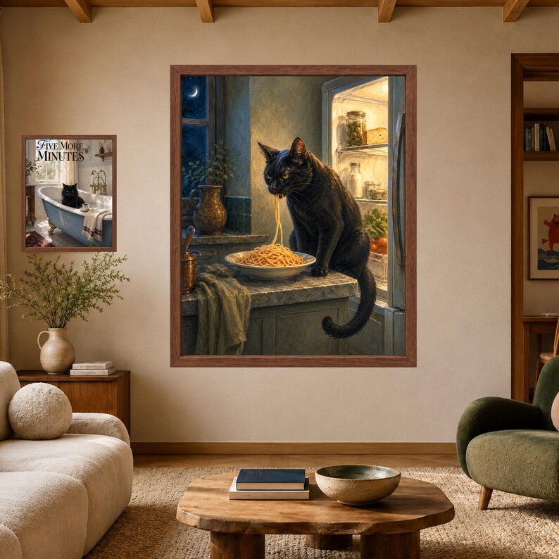 May include: A framed wall art print featuring a black cat eating spaghetti from a bowl on a kitchen counter next to an open refrigerator. A second smaller framed print shows a black cat in a bathtub with the text Five More Minutes.