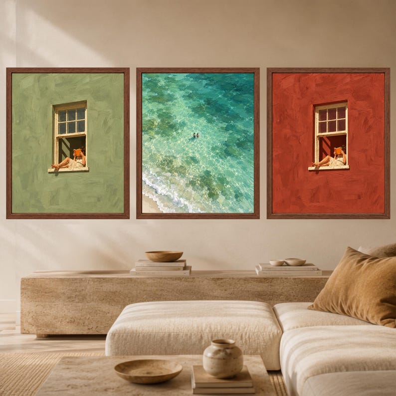 May include: A set of three framed wall art prints. The left print shows a person reading in a green window, the center print depicts a turquoise ocean with two swimmers, and the right print shows a person reading in a red window.