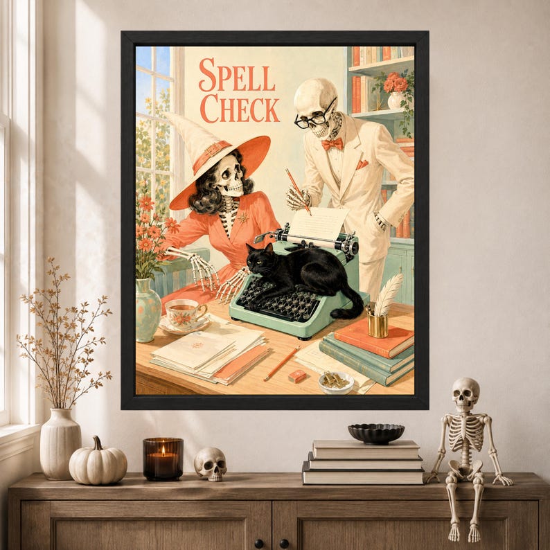 Pu&ograve; includere: Una stampa artistica incorniciata intitolata Spell Check che mostra uno scheletro con cappello da strega e uno scheletro in abito davanti a una scrivania con una macchina da scrivere. Un gatto nero siede sulla macchina, circondato da libri e una tazza.