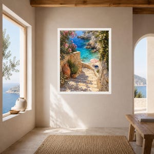 Peut inclure: Une impression d'art encadr&eacute;e repr&eacute;sentant un escalier en pierre menant &agrave; une crique m&eacute;diterran&eacute;enne turquoise. La sc&egrave;ne pr&eacute;sente des fleurs de laurier-rose, un pot en terre cuite et une petite plage avec un parasol ray&eacute; rouge et blanc.