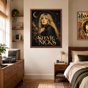 Puede incluir: Un p&oacute;ster de pared enmarcado que presenta un retrato de Stevie Nicks en un entorno oscuro de tem&aacute;tica celestial con una luna creciente y estrellas. La obra est&aacute; realizada en tonos negros y dorados, con el nombre Stevie Nicks en una fuente estilizada.