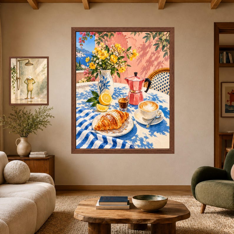 May include: A framed wall art print depicting a breakfast scene on a balcony with a croissant, a cup of coffee, a moka pot, a vase of yellow flowers, and lemon slices on a blue and white striped tablecloth, with a coastal view in the background.
