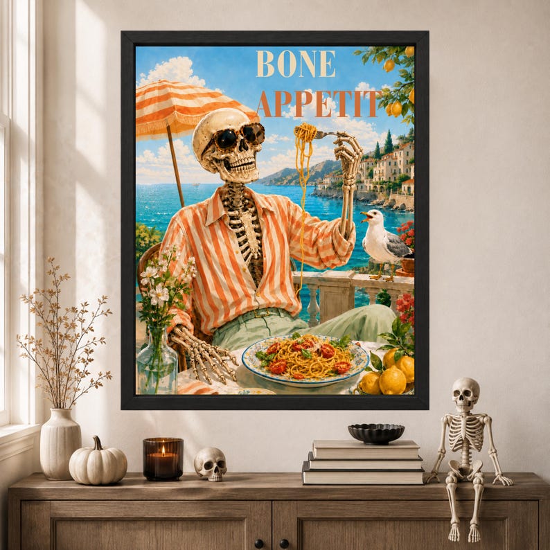 Peut inclure: Une impression d'art encadr&eacute;e repr&eacute;sentant un squelette portant des lunettes de soleil et une chemise &agrave; rayures orange, mangeant des p&acirc;tes &agrave; une table c&ocirc;ti&egrave;re. Le texte BONE APPETIT est imprim&eacute; en haut. Un go&eacute;land, un citronnier et un parasol sont visibles.