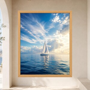 Pode incluir: Uma impress&atilde;o art&iacute;stica emoldurada apresentando um veleiro branco em &aacute;guas azuis calmas sob um c&eacute;u brilhante com nuvens leves e luz solar. A obra est&aacute; em uma moldura de madeira clara, exibindo uma cena mar&iacute;tima serena com horizonte.