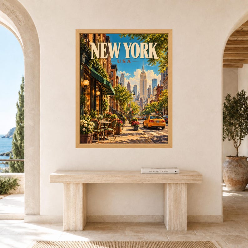 May include: A framed wall art print featuring a sunny New York City street scene with the text NEW YORK USA at the top. The image displays a sidewalk cafe with green awnings, potted flowers, a yellow taxi cab, and the Empire State Building in the distance.
