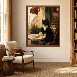 May include: A framed wall art print depicting a black and white tuxedo cat sitting on a woven chair at a small round cafe table. On the table sits a white coffee cup and a newspaper. The background shows a Parisian street scene with the Eiffel Tower.